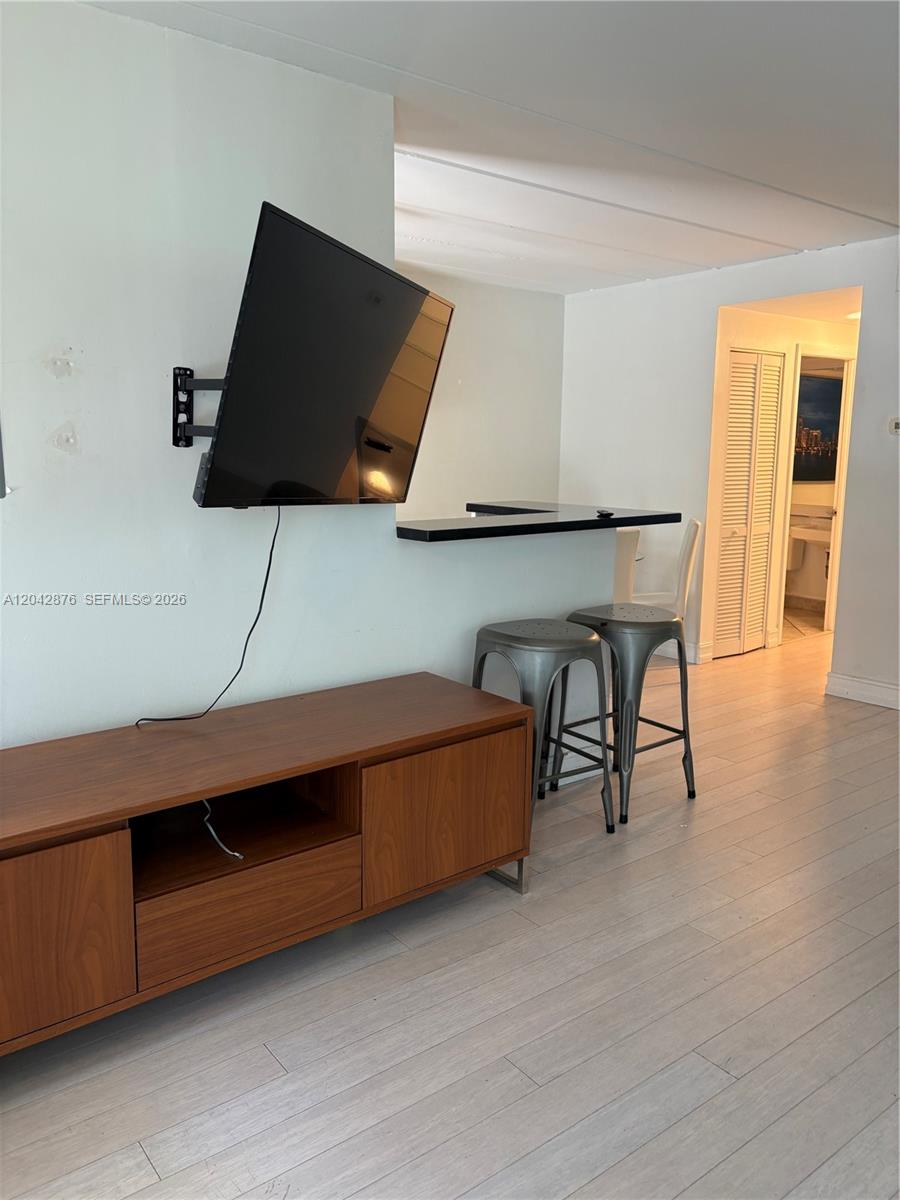 A living area features a wall-mounted television, a wooden media console, and a breakfast bar — 1545 Euclid Ave # 2F, Miami Beach FL 33139, MIAMI BEACH, FL