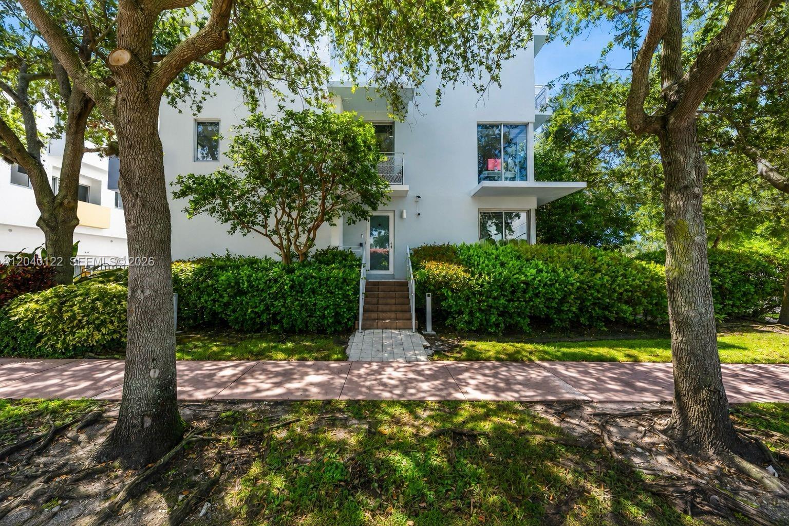 A white multi-story building exterior features a central staircase, a balcony, and surrounding trees — 193 N Shore Dr # 6, Miami Beach FL 33141, MIAMI BEACH, FL