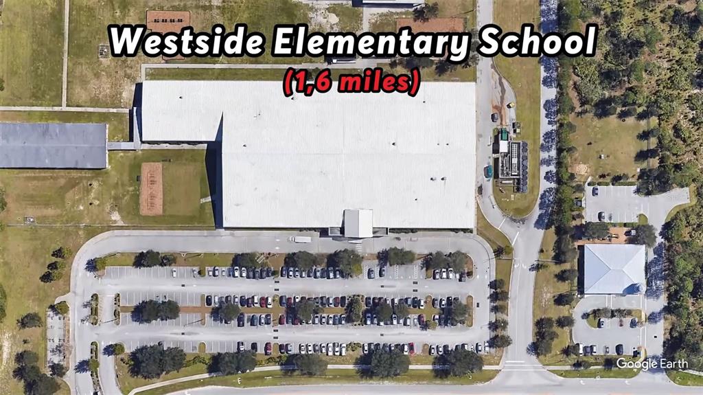 This aerial view shows the school building, parking lot, and surrounding grounds — 328 DADEVILLE STREET SE, PALM BAY, FL