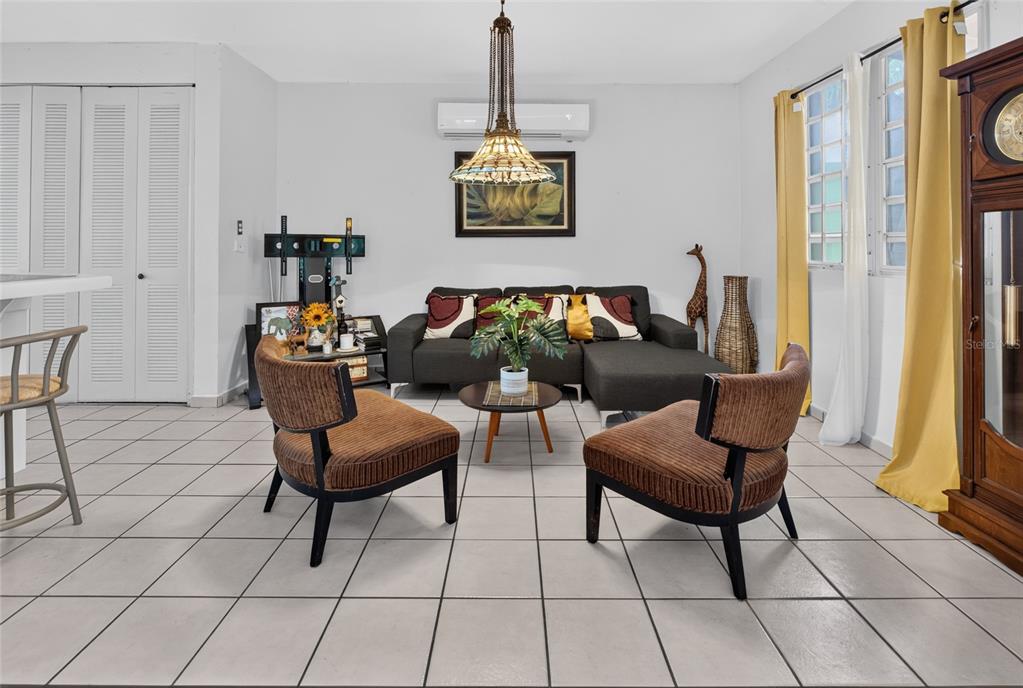 A living room features a dark sectional sofa, two brown chairs, and a tiled floor — B-21 MANSIONES DE CABO ROJO, CABO ROJO, PR