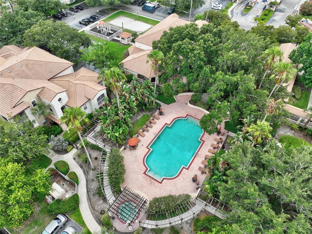 An aerial view shows a swimming pool and hot tub surrounded by trees and buildings — 829 CAMARGO WAY UNIT 209, ALTAMONTE SPRINGS, FL