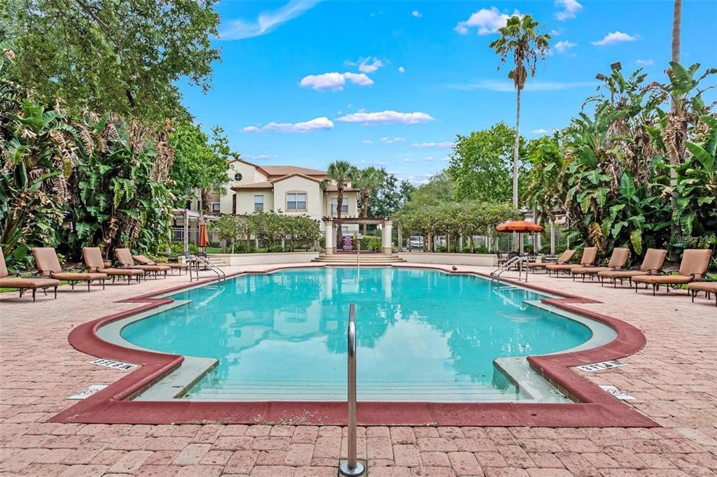 A rectangular swimming pool with a brick deck surrounded by lush landscaping and apartment buildings — 829 CAMARGO WAY UNIT 209, ALTAMONTE SPRINGS, FL
