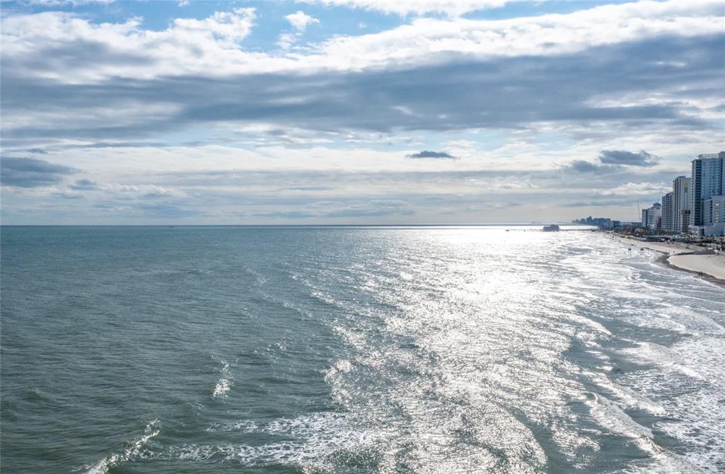 An aerial view of a sandy beach coastline with high-rise buildings and a pier — 800 N ATLANTIC AVENUE UNIT 705, DAYTONA BEACH, FL