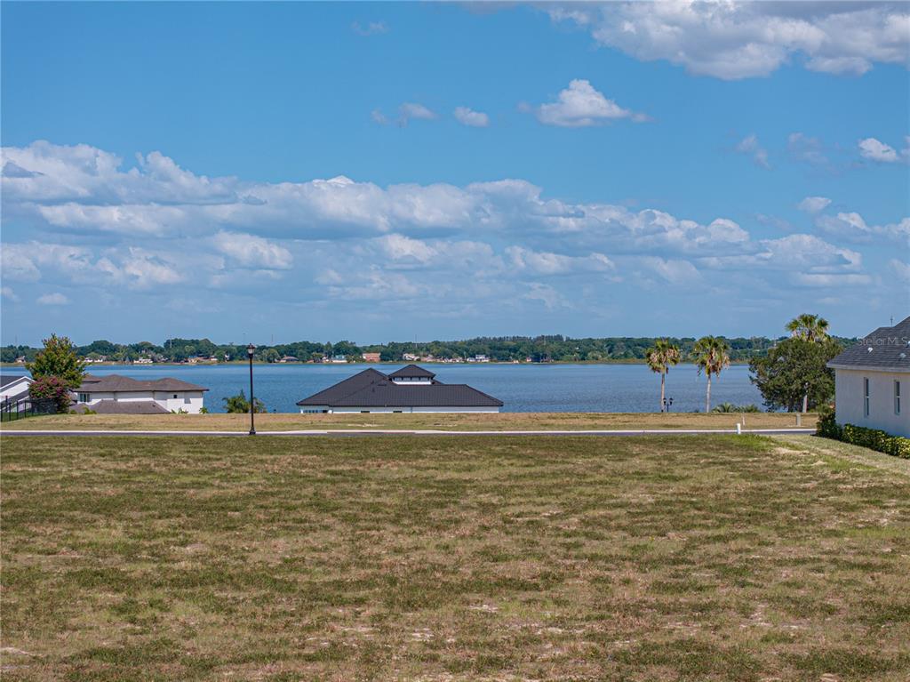 A vacant grassy lot overlooks a large lake with houses along the distant shoreline — 158 BLAZING STAR AVENUE, LAKE ALFRED, FL