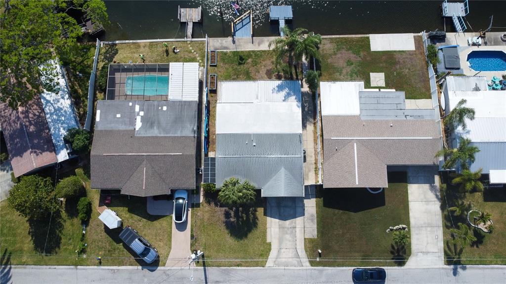 An aerial view shows three waterfront houses with pools, driveways, and private docks — 12739 1ST ISLE, HUDSON, FL