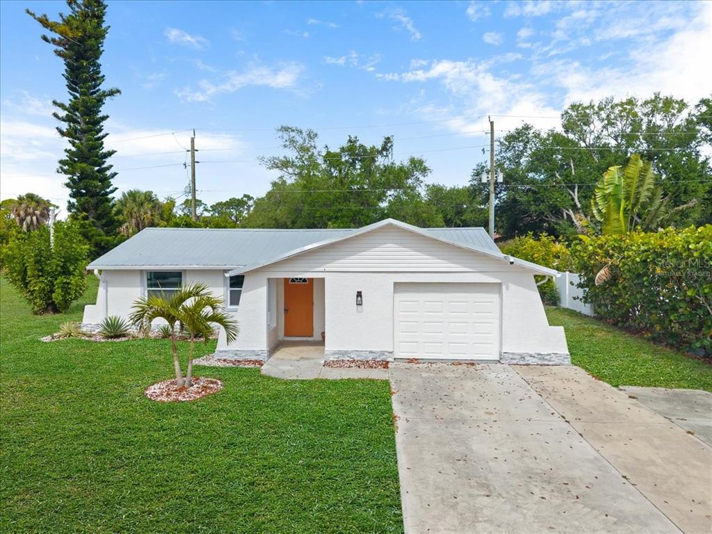 An aerial view shows a single-story house outlined in white, situated along a road — 2580 SHAMROCK DRIVE, VENICE, FL