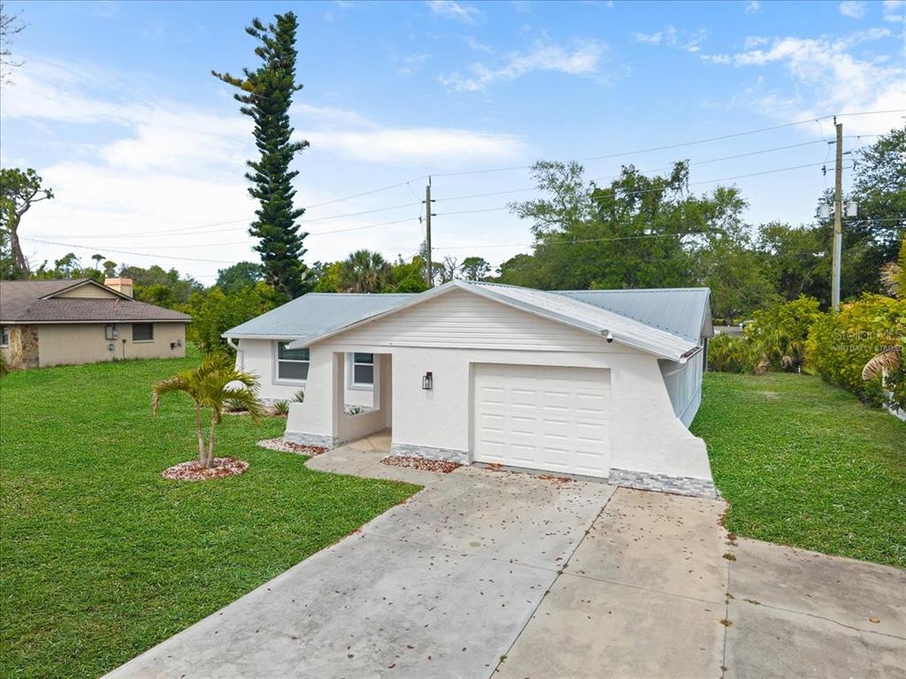 An open-concept living area features light wood flooring, recessed lighting, and a white kitchen — 2580 SHAMROCK DRIVE, VENICE, FL