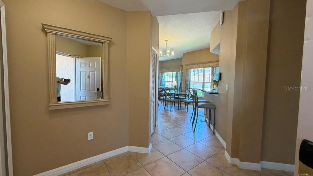 A tiled entryway leads to a dining area with a breakfast bar and large windows — 8601 WORLDQUEST BOULEVARD UNIT 3201, ORLANDO, FL
