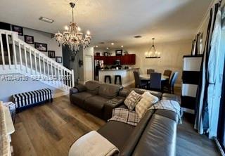 A living room with wood floors, a large sectional sofa, and a staircase with railings — 16320 SW 71st Ter, Miami FL 33193, MIAMI, FL