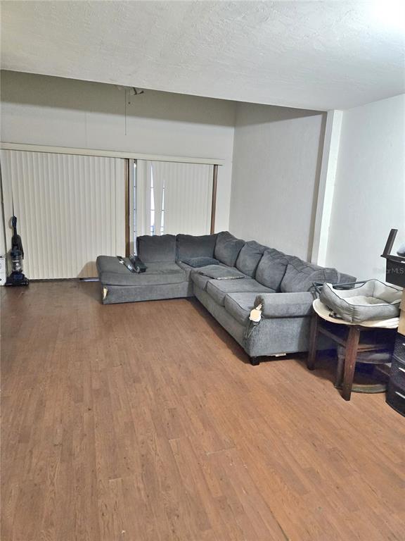 A living room features a large gray sectional sofa on wood-look flooring near sliding doors — 5727 SW 10TH PLACE, GAINESVILLE, FL