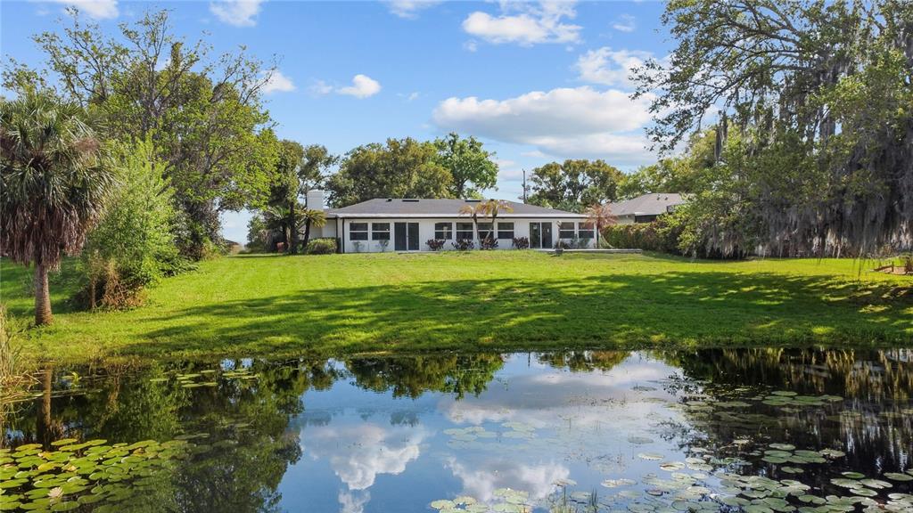 An aerial view of a white single-story house with a dark shingled roof and landscaping — 1501 DRUID ISLE ROAD, MAITLAND, FL