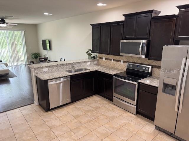 A kitchen with dark wood cabinets, granite countertops, and stainless steel appliances — 8723 TURNSTONE HAVEN PLACE, TAMPA, FL