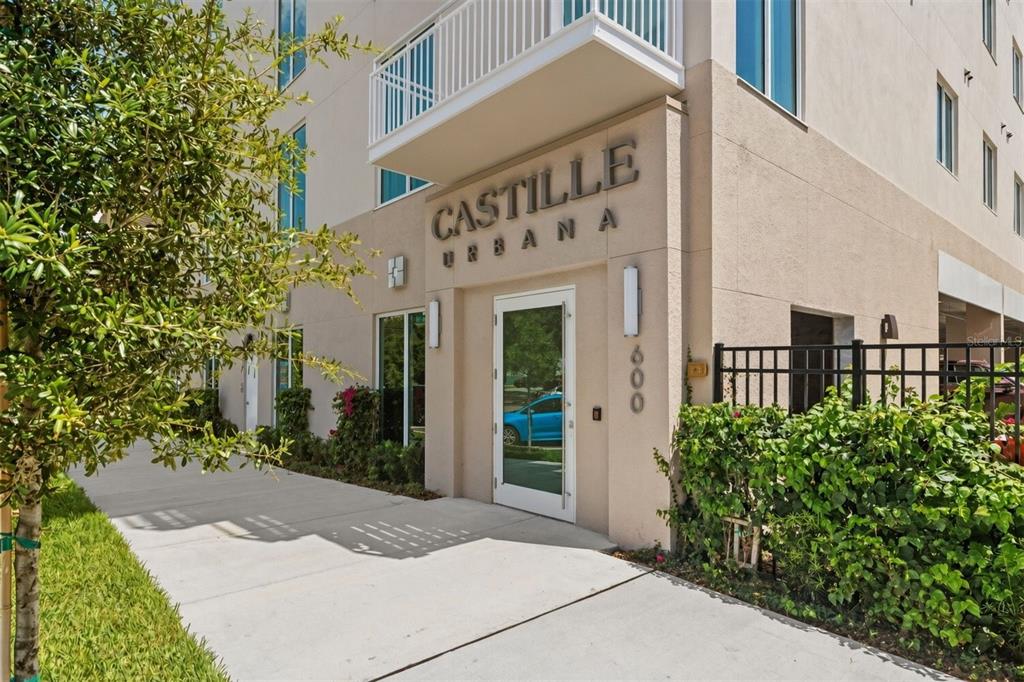The exterior entrance of a modern apartment building features a sign reading Castille Urbana — 600 3RD AVENUE S UNIT 207, ST PETERSBURG, FL