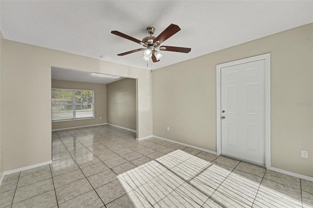 A room with light-colored tile flooring, a ceiling fan, and a white door — 1822 JASPER DRIVE, ORLANDO, FL