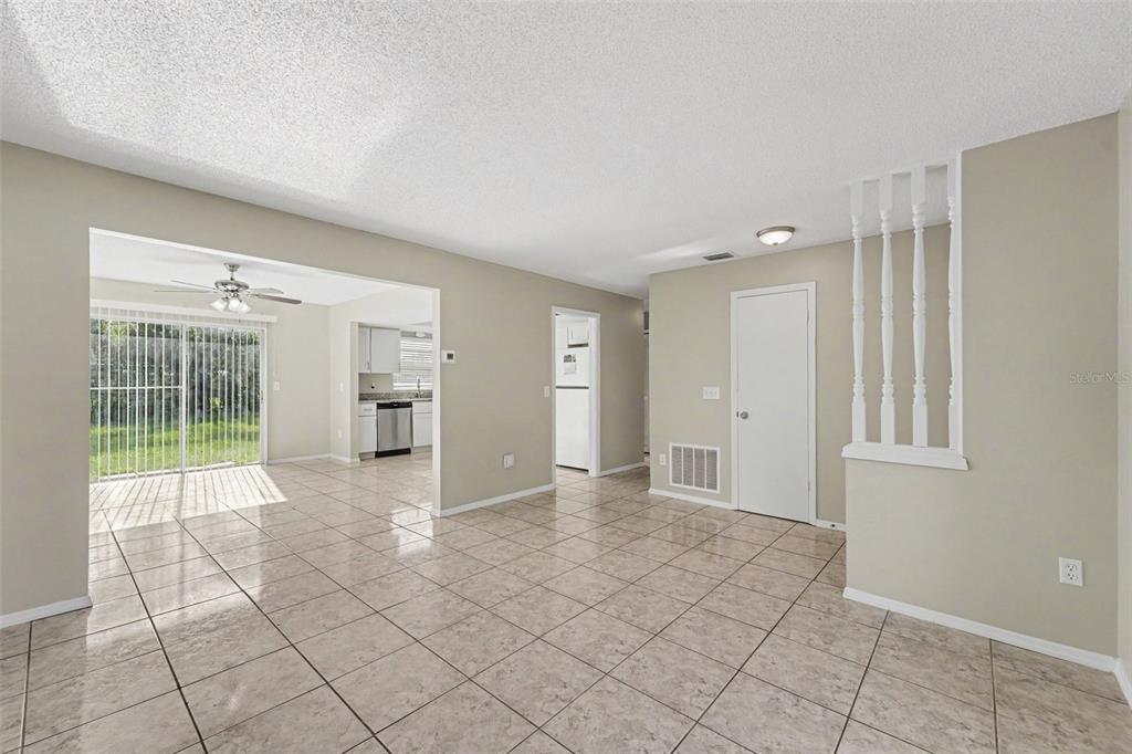 A tiled dining area features a sliding glass door, an adjacent kitchen, and white spindles — 1822 JASPER DRIVE, ORLANDO, FL