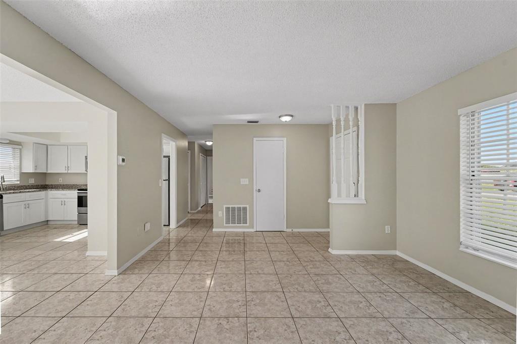 A tiled dining area features a white door, a decorative spindle partition, and a kitchen — 1822 JASPER DRIVE, ORLANDO, FL