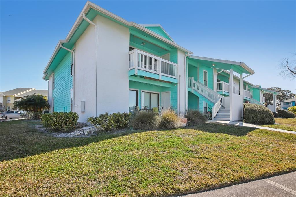 A two-story building with teal siding, white trim, and an outdoor staircase — 455 ALT 19 S UNIT 42 & 46, PALM HARBOR, FL