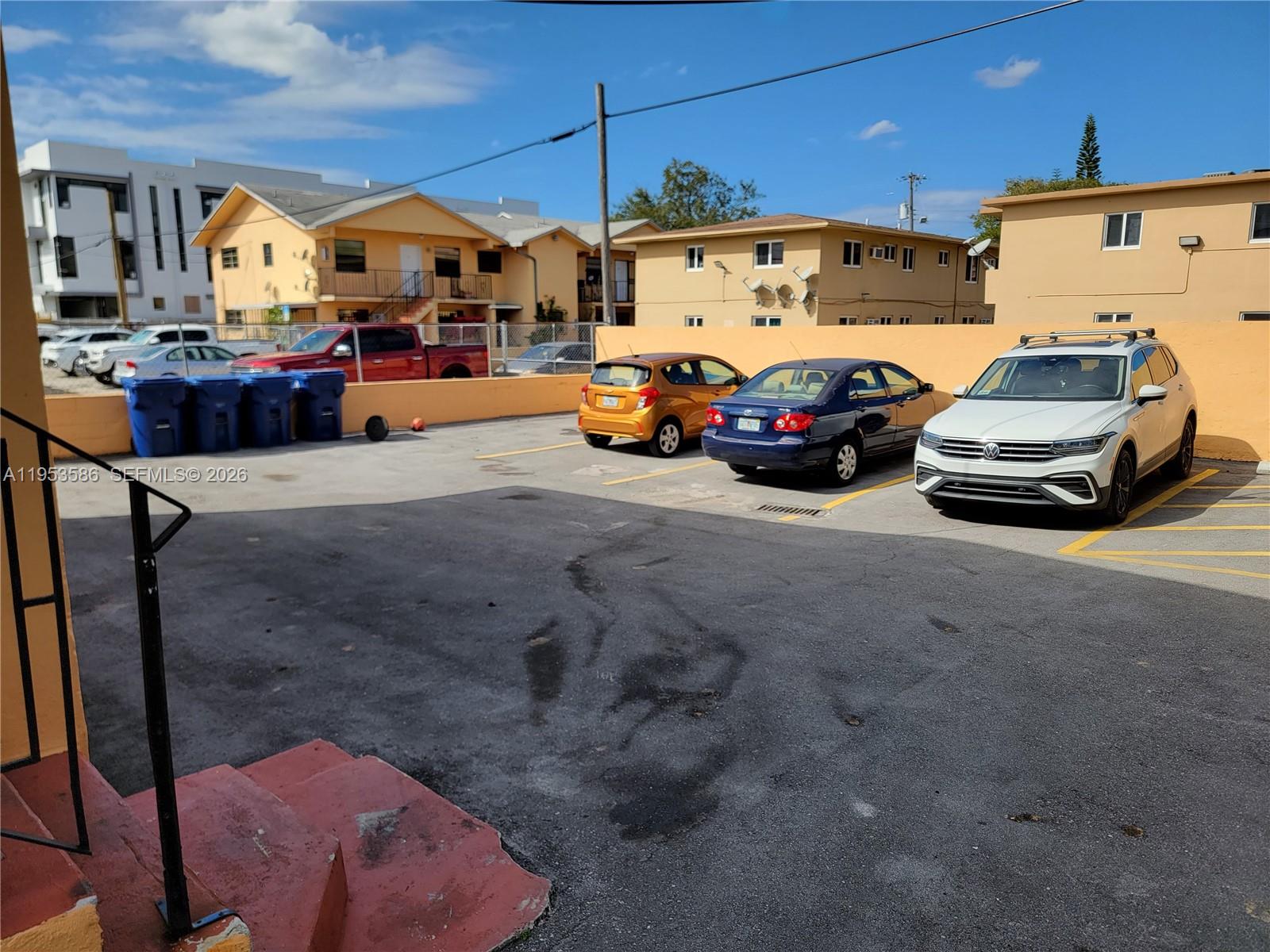 An outdoor parking lot features three parked cars and several blue trash bins — 1753 SW 6th St, Miami FL 33135, MIAMI, FL