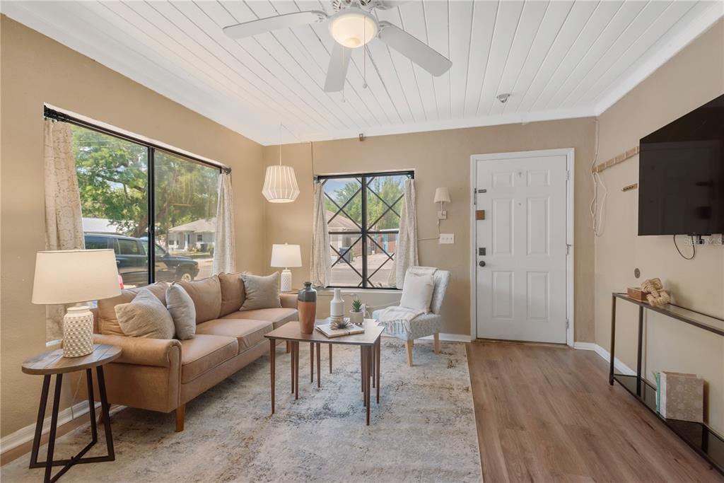 A living room features a tan sofa, a patterned rug, and a ceiling fan — 1315 E OSBORNE AVENUE, TAMPA, FL