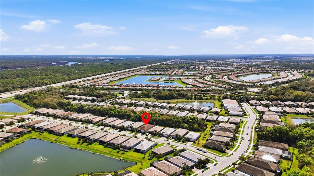 An aerial view shows a residential neighborhood with houses, ponds, and a red location marker — 12031 LOVEGRASS STREET, VENICE, FL