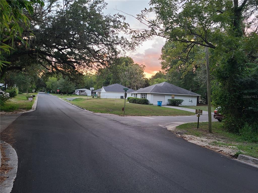 A street view shows a residential corner lot with white houses and mature trees — NW 183 PLACE, HIGH SPRINGS, FL