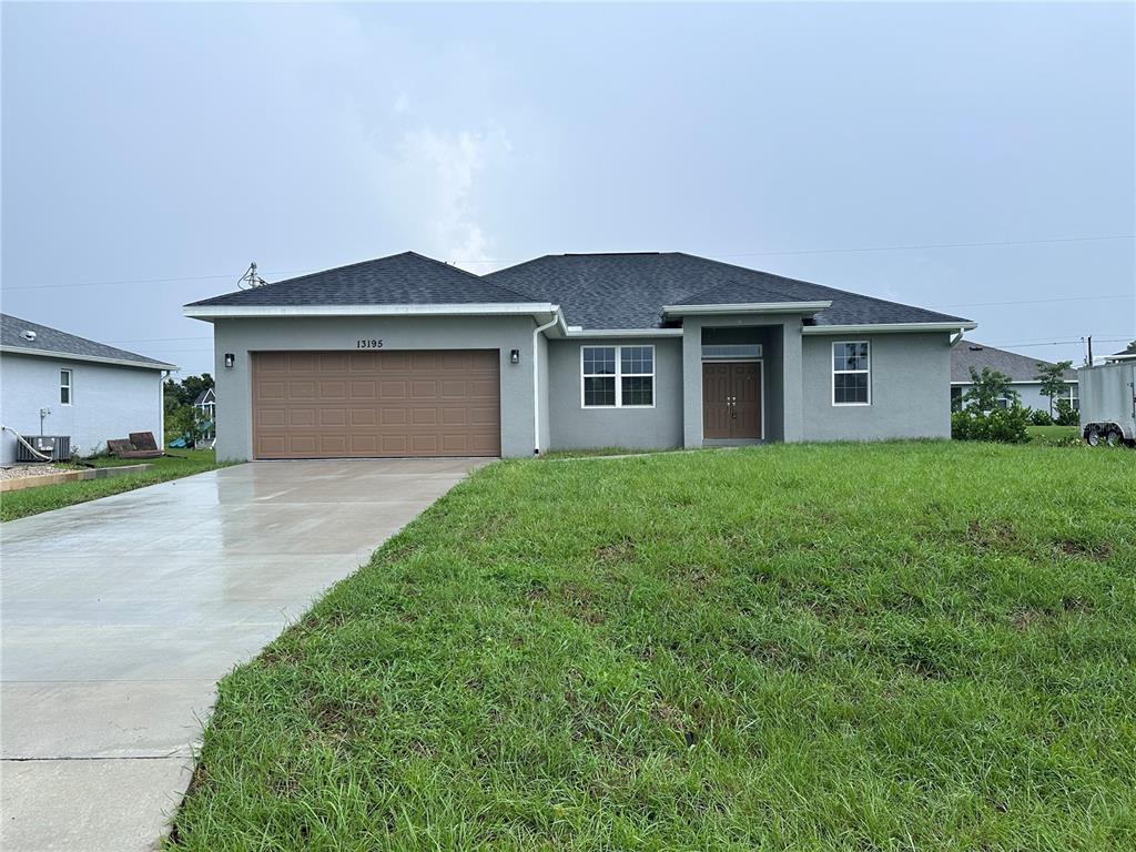 A single-story gray house with a two-car garage and a front entrance under a portico — 13195 DRYSDALE AVENUE, PORT CHARLOTTE, FL