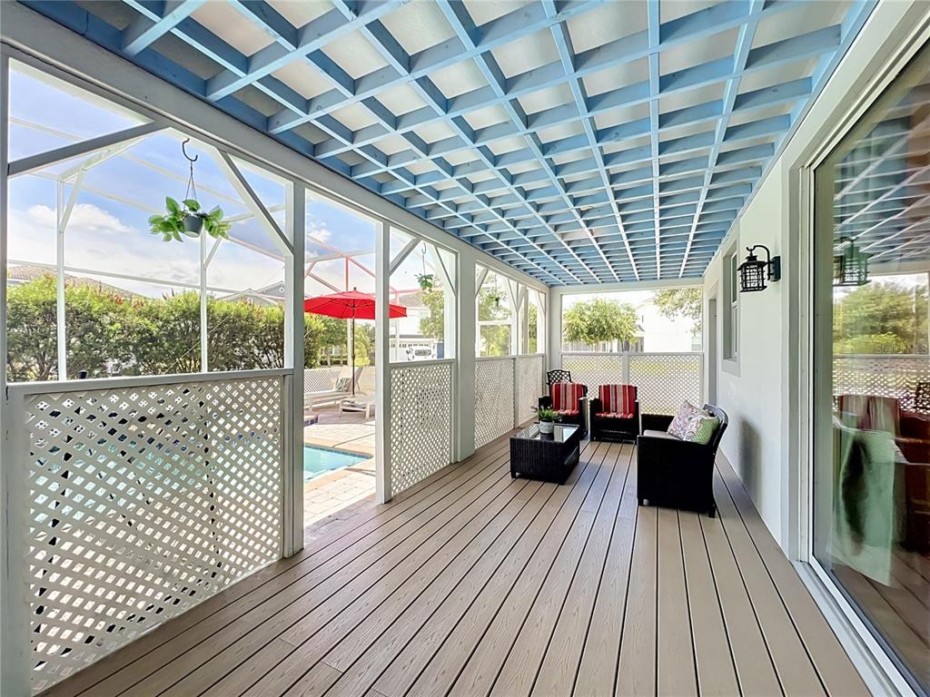 A covered patio with a blue lattice ceiling, wood-look flooring, and a view of a pool — 1573 MAIDSTONE COURT, DAVENPORT, FL