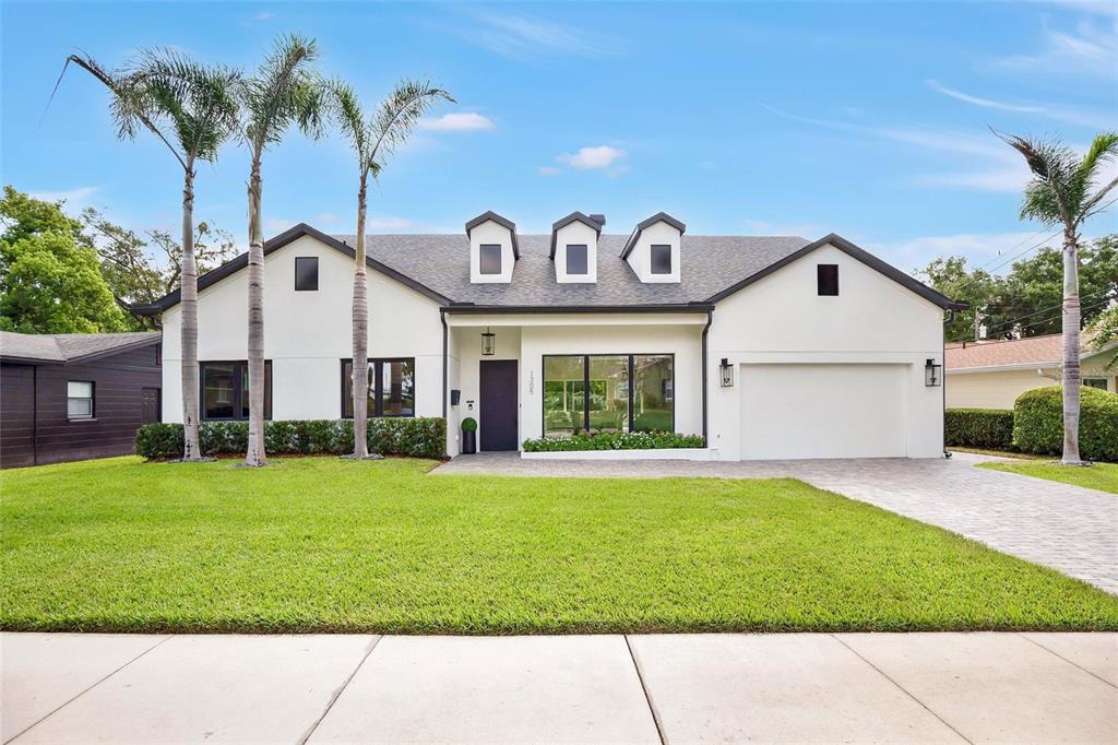 A white, single-story house with a dark roof, three dormers, and a paved driveway — 1305 BELMONT DRIVE, ORLANDO, FL
