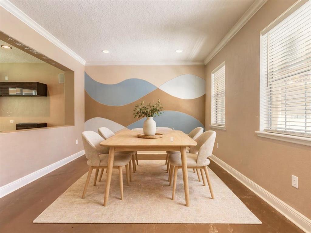 A dining room features a light wood table, upholstered chairs, and a wavy-patterned accent wall — 3365 PEGASO AVENUE, NEW SMYRNA BEACH, FL