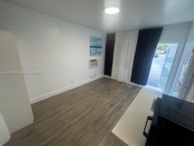A room with wood-look flooring, white walls, a window air conditioner, and a glass door — 9920 Collins Ave # 23, Bal Harbour FL 33154, BAL HARBOUR, FL