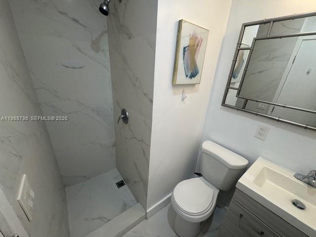 A bathroom features a walk-in shower with marble-look tile, a toilet, and a vanity sink — 9920 Collins Ave # 23, Bal Harbour FL 33154, BAL HARBOUR, FL