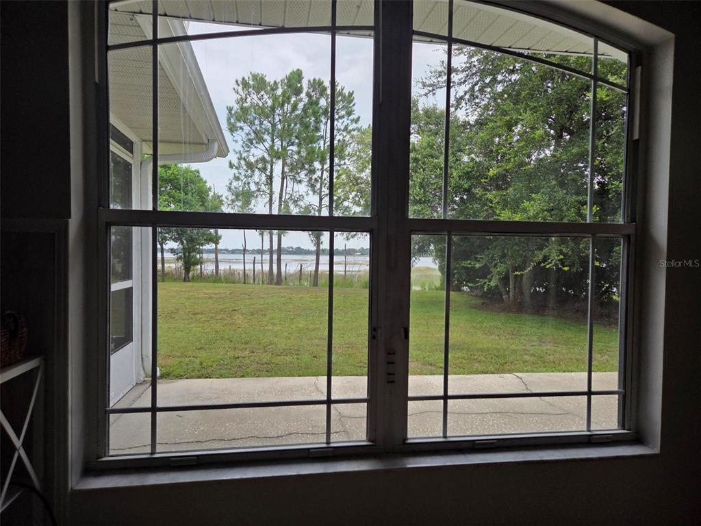 A green house exterior features a red front door, arched windows, and a white fence — 2562 TRAVIDA DRIVE, DELTONA, FL