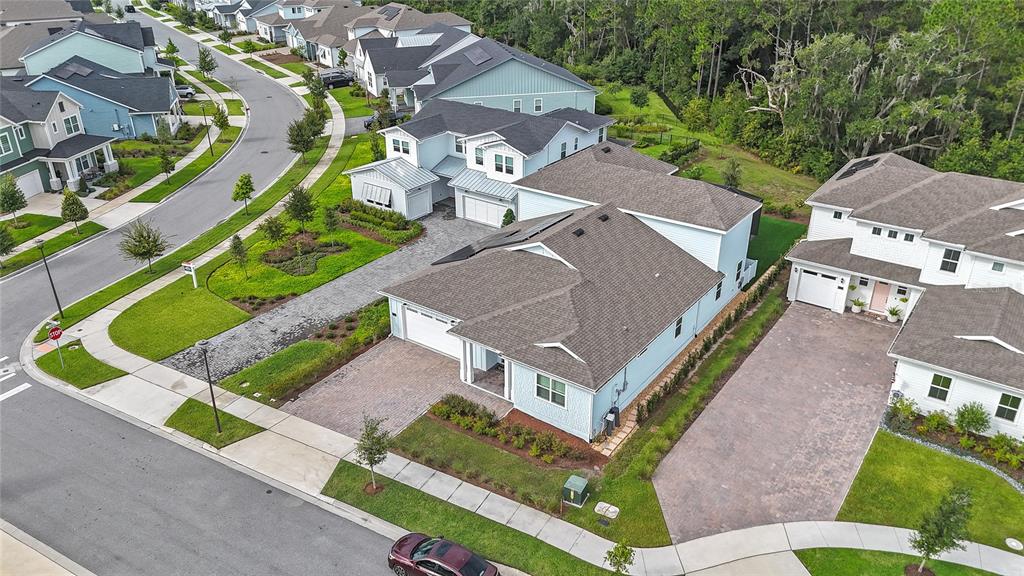 An aerial view shows several light blue suburban houses with paved driveways and green lawns — 3126 VANGUARD COURT, ST CLOUD, FL