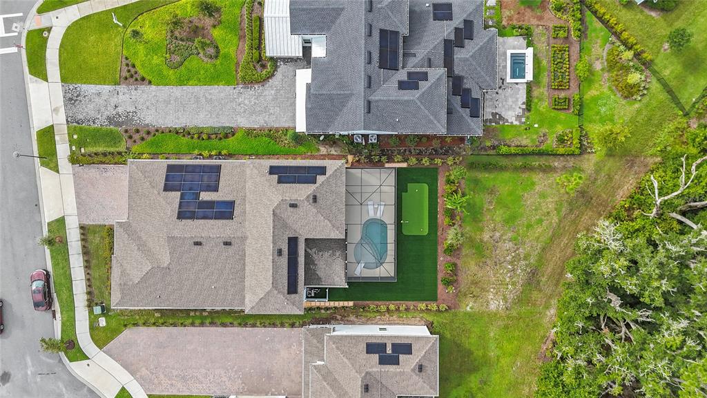 An aerial view shows a house with a pool, putting green, and solar panels — 3126 VANGUARD COURT, ST CLOUD, FL