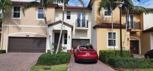An entryway features a glass console table, a dark rug, and a white front door — 6960 Long Pine Circle, Coconut Creek FL 33073, COCONUT CREEK, FL
