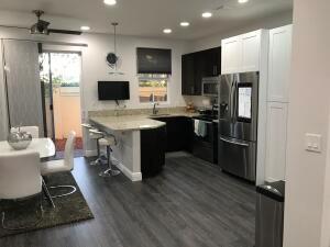 An entryway features a staircase with grey wood-look steps, a metal bench, and grey flooring — 6960 Long Pine Circle, Coconut Creek FL 33073, COCONUT CREEK, FL