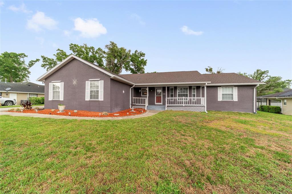 A single-story house with dark gray stucco siding, a brown roof, and a front porch — 4807 SE 14TH STREET, OCALA, FL