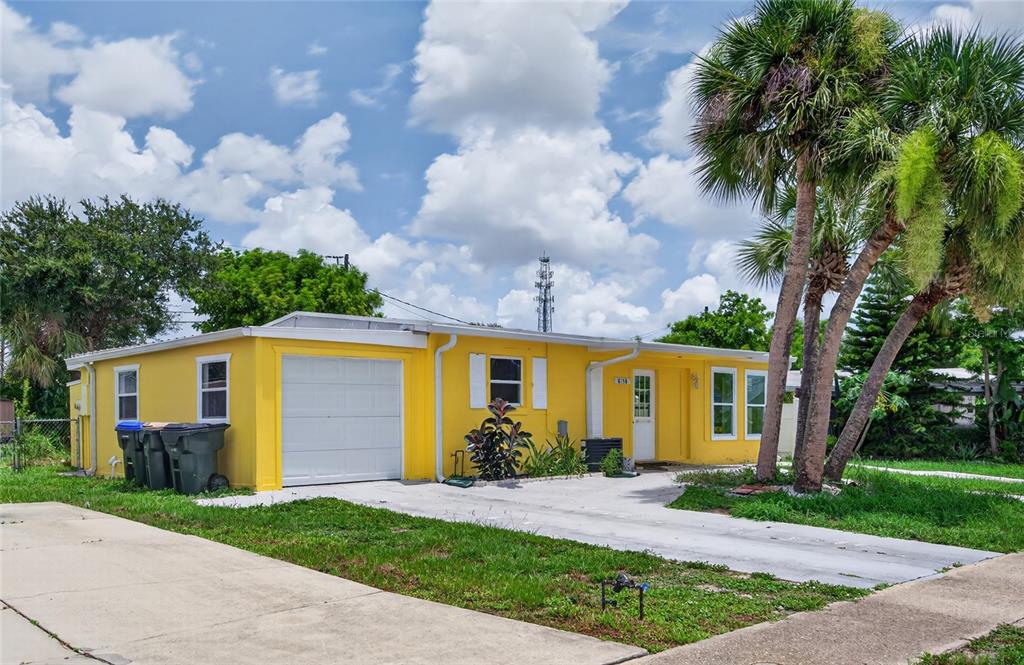 A yellow single-story house with a white garage door and palm trees in the front yard — 8158 AGRESS AVENUE, NORTH PORT, FL