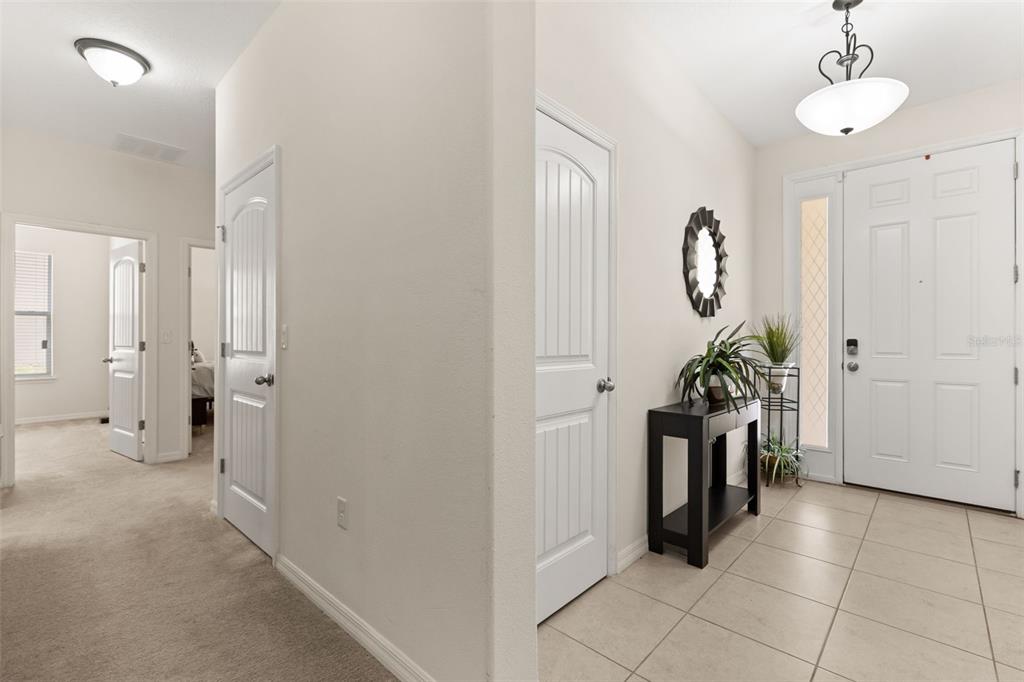 An entryway with tile flooring, a console table, and a white front door — 3737 CHANDLER ESTATES DRIVE, APOPKA, FL