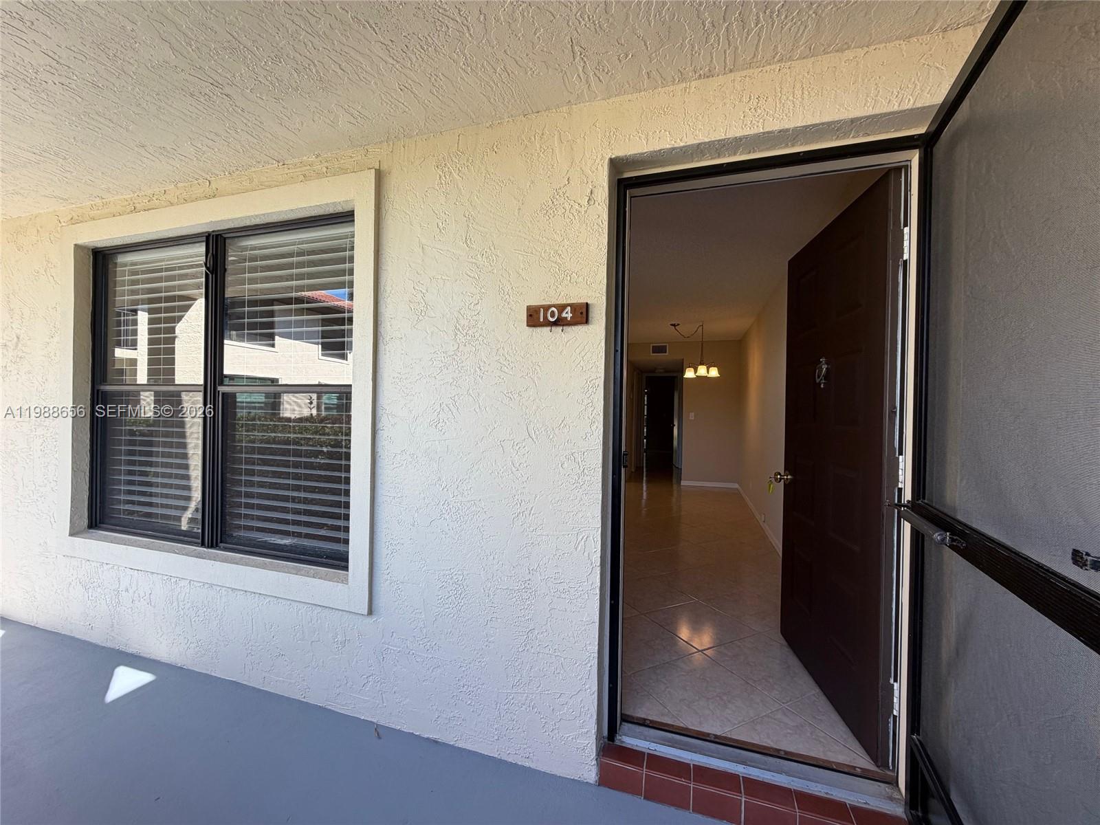 The exterior view shows a building entrance with a window and an open door — 301 SW South River Dr # 104, Stuart FL 34997, STUART, FL