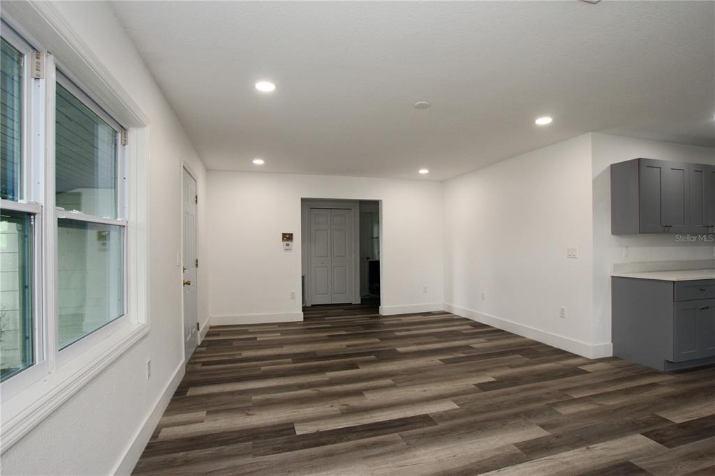 This room features wood-look flooring, white walls, recessed lighting, and a partial view of cabinetry — 4925 MAGNOLIA AVENUE, MULBERRY, FL