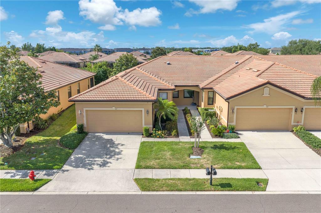 An aerial view of two attached suburban homes with tan stucco walls and tiled roofs — 107 SHELL FALLS DRIVE, APOLLO BEACH, FL