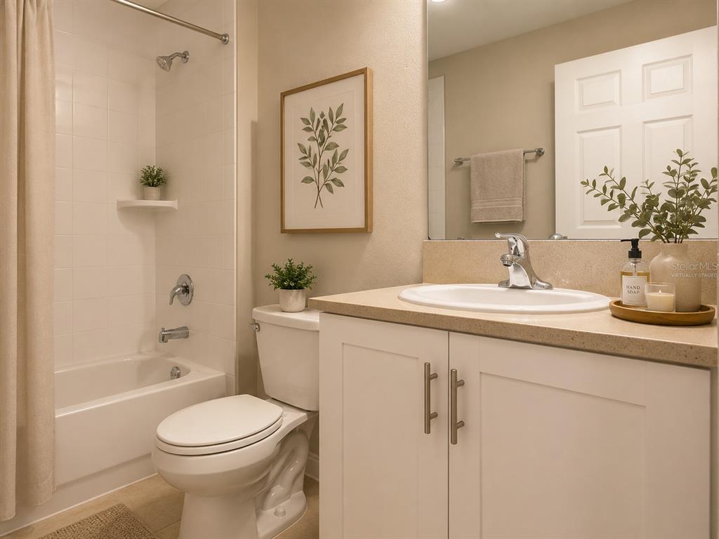 A bathroom features a white vanity, a toilet, and a shower-tub combination with white tile — 1341 DERRY AVENUE, HAINES CITY, FL