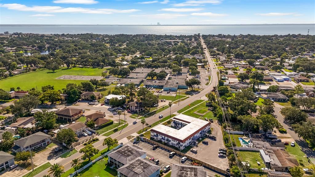 An aerial view shows a residential neighborhood with a multi-story apartment complex and nearby houses — 955 KNOX MCRAE DRIVE, TITUSVILLE, FL