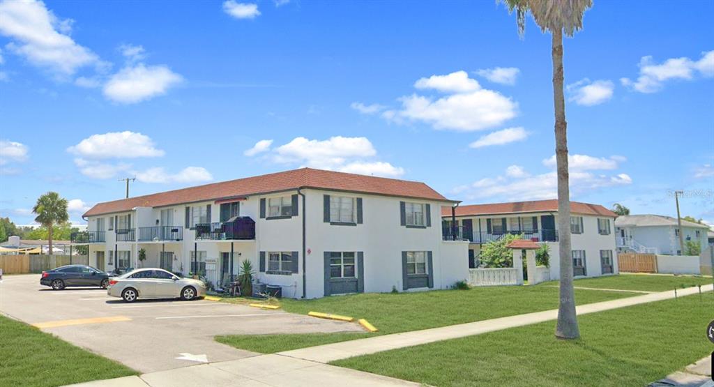 A two-story apartment building with a parking lot and a palm tree in the front — 955 KNOX MCRAE DRIVE, TITUSVILLE, FL
