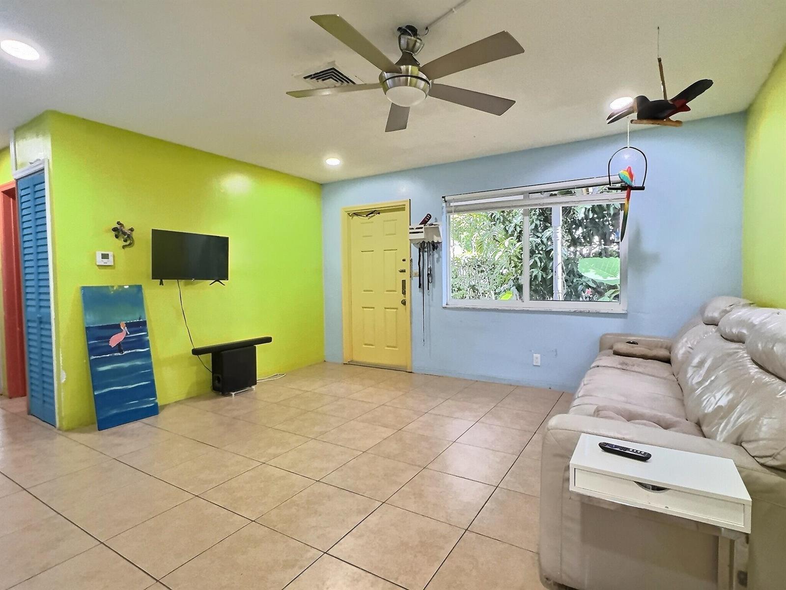 A living room features lime green and light blue walls, tile flooring, and a ceiling fan — 4570 NW 16th Terrace, Tamarac FL 33309, TAMARAC, FL
