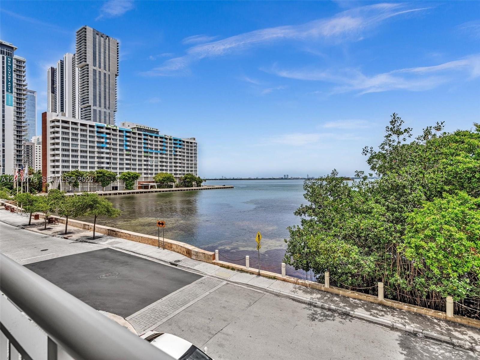 A view from a balcony overlooking a street, a bay, and nearby high-rise buildings — 2000 N Bayshore Dr # 220, Miami FL 33137, MIAMI, FL