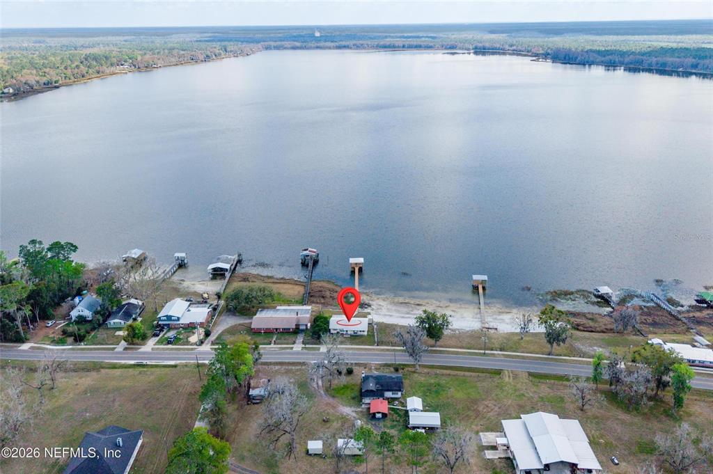 An aerial view shows a house with a dock on a large lake — 7932 SW COUNTY ROAD 18, HAMPTON, FL
