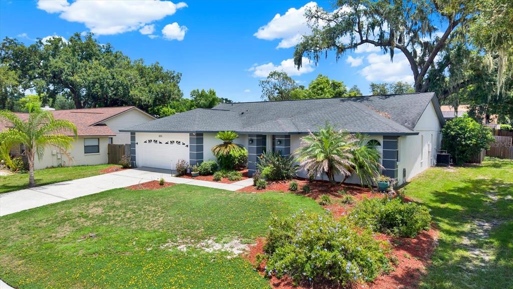 A single-story house with a white exterior, gray trim, and a large front lawn — 1805 TAWNEE PLACE, BRANDON, FL