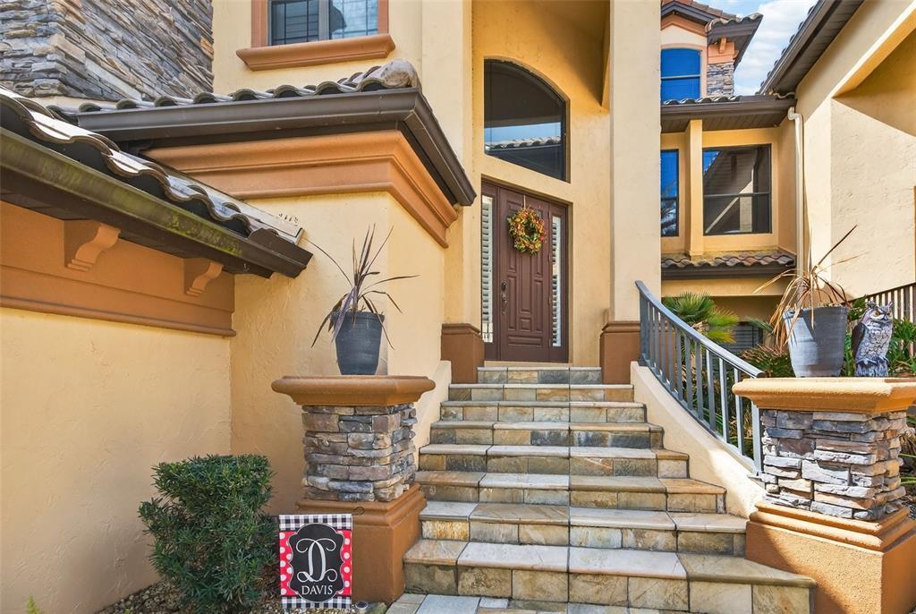 A stone-tiled staircase leads to the front entrance of a stucco home with stone pillars — 1105 W POINTE VISTA PATH UNIT 43, HERNANDO, FL